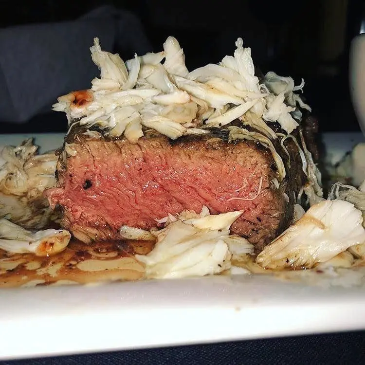 A piece of meat on top of a white plate.